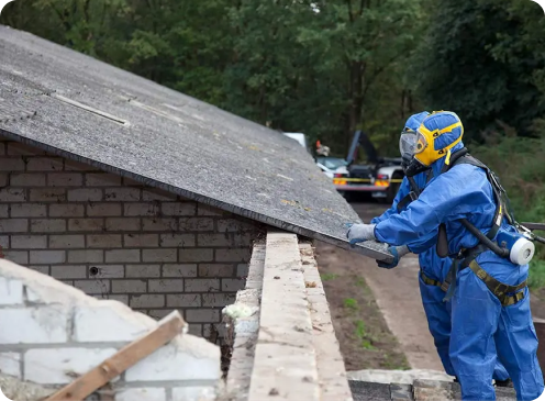 Retirada de Amianto en Segovia 5 Trabajador con traje de protección retirando planchas de amianto de un tejado en Segovia