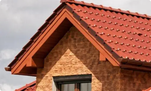 Tejados y Cubiertas en Segovia 2 Tejado de tejas metálicas rojas sobre fachada de ladrillo decorativo en Segovia