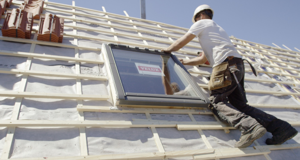 Instalación de ventanas velux en Segovia 2 Profesional instalando una ventana Velux en el tejado de una vivienda en Segovia