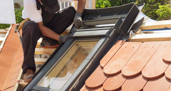 Instalación de ventanas velux en Segovia 3 Técnico instalando ventana Velux en un tejado con tejas cerámicas en Segovia
