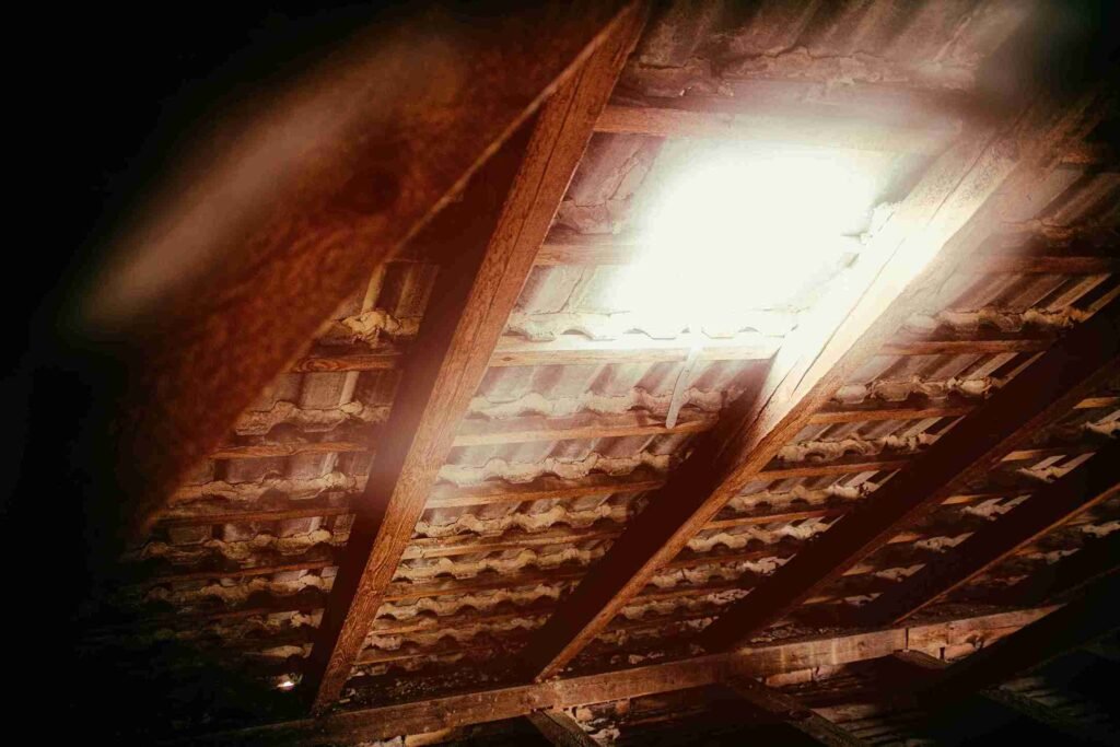 Reparación de Cubiertas de Madera: Guía Completa para Tejados y Estructuras de Madera con Tejas Duraderas 1 Vista interior de una estructura de vigas y tejas mostrando una antigua cubierta de madera en restauración