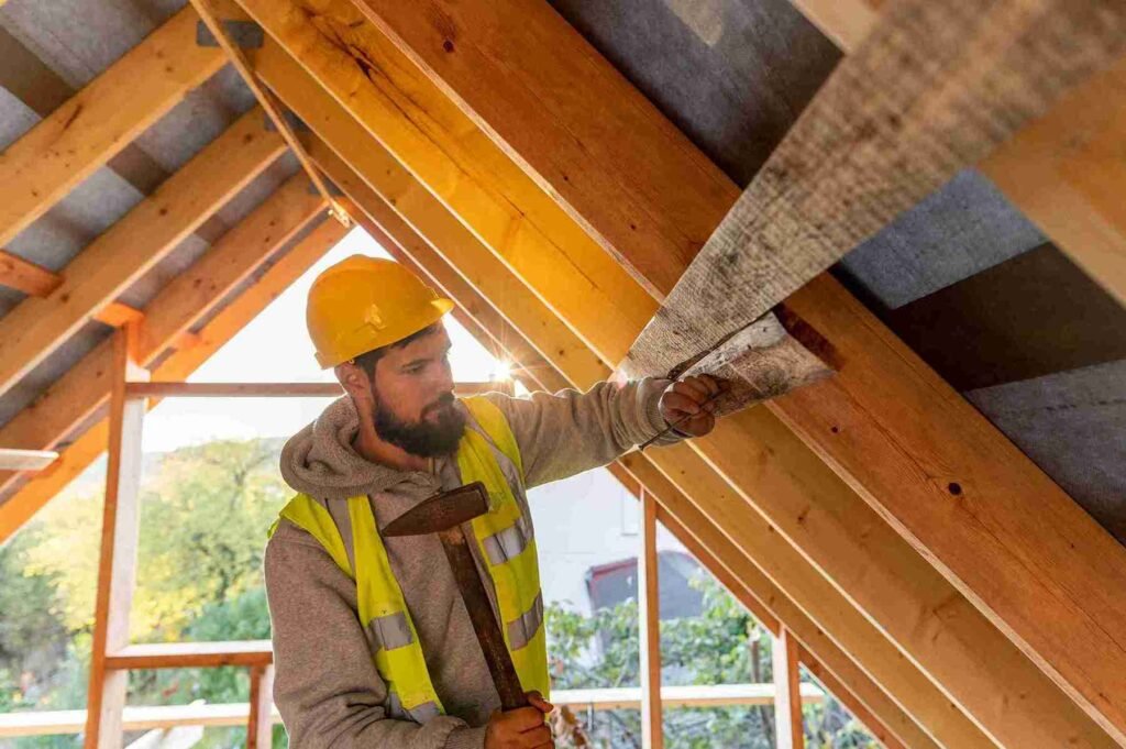 Reparación de Cubiertas de Madera: Guía Completa para Tejados y Estructuras de Madera con Tejas Duraderas 2 Obrero con casco y martillo trabajando en la reparación y rehabilitación de cubiertas de madera en una vivienda